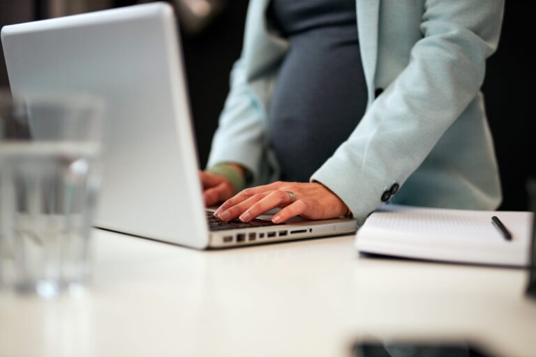 Expecting mother at work researching pregnancy disclosure