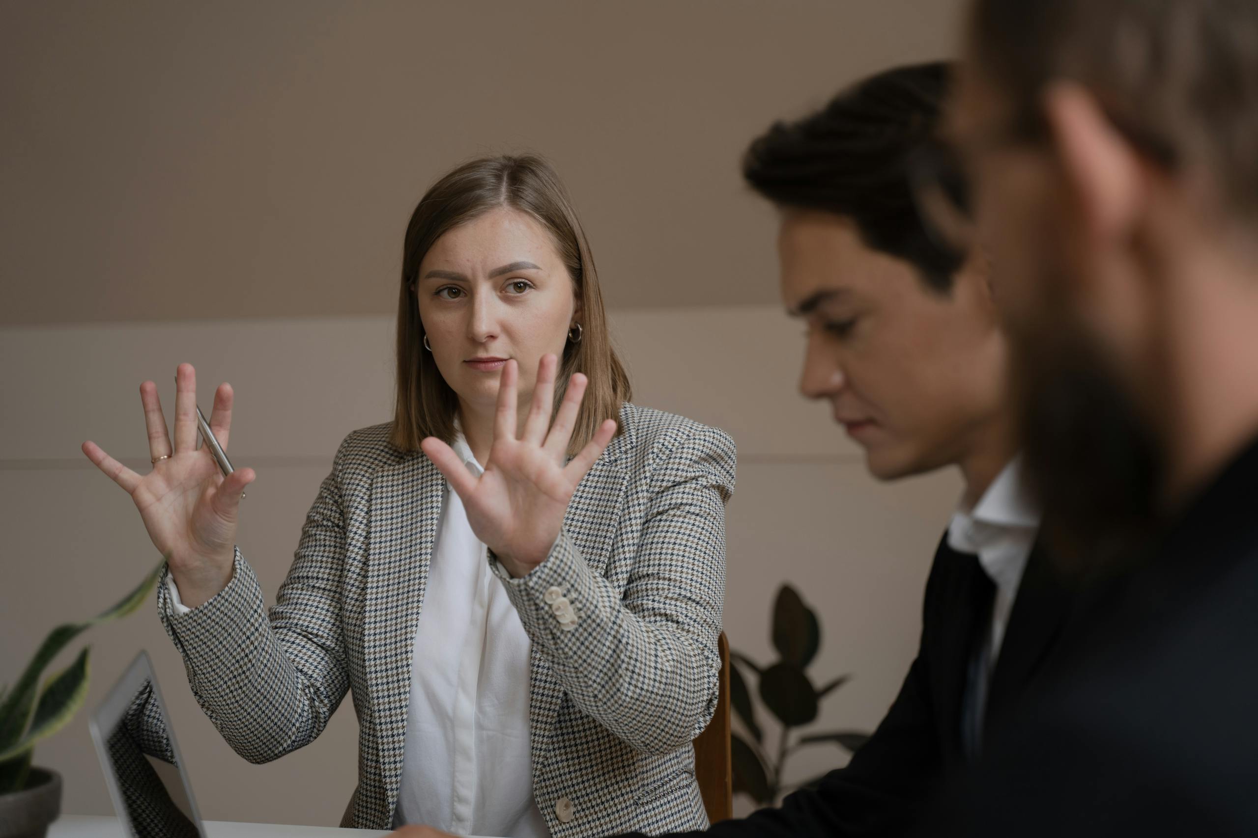 Three professionals in a mandatory meeting. Employer forcing staff to listen to their personal views.