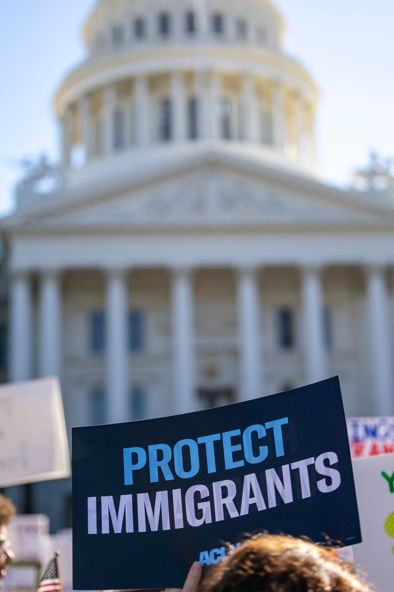 Sign reading 'Protect Immigrants' seen at a protest in front of the California State Capitol in Sacramento.